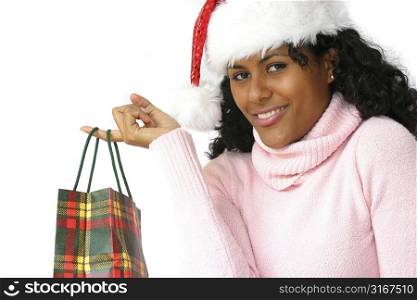 Beautiful brazilian girl with santa hat looking very happy with her giftbag