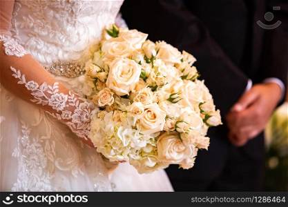 Beautiful bridal wedding bouquet isolated in hands with blurred groom together. Beautiful bridal wedding bouquet isolated in hands with blurred groom