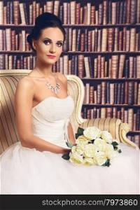 Beautiful Bride. beautiful young woman in wedding dress sitting on sofa