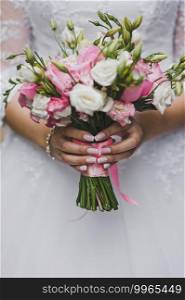 Beautiful bride bouquet in her hands closeup.. Delicate bouquet of pink and white flowers in the hands of the bride 214