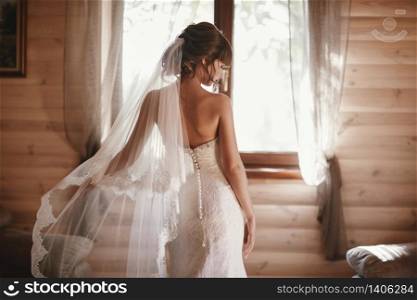 beautiful bride in a dress turned her back on the camera. Beautiful bride with fashion veil. Tender bride in wedding dress. beautiful bride in a dress turned her back on the camera. Beautiful bride with fashion veil. Tender bride in wedding dress.