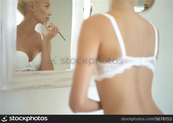 Beautiful bride in the mirror corrects make-up. Fashion art photo