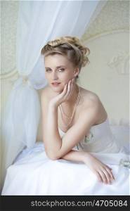 Beautiful bride in white wedding dress at home