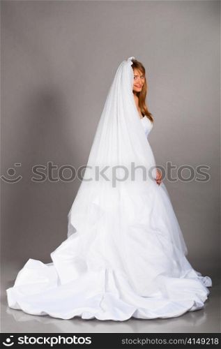 beautiful bride is standing in wedding dress on grey background