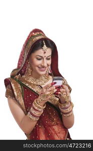 Beautiful bride looking at an sms