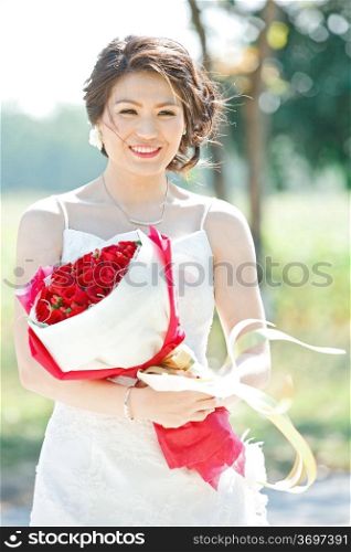 beautiful bride outdoors with rose bouquet
