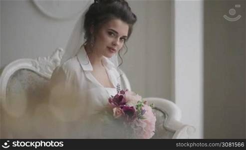 Beautiful bride posing in her wedding day with flower bouquet