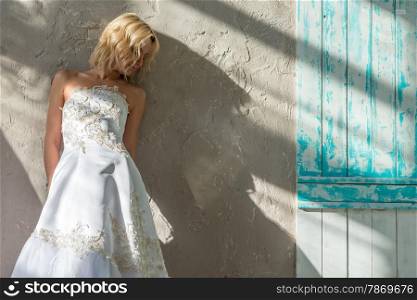 beautiful bride standing near a gray wall