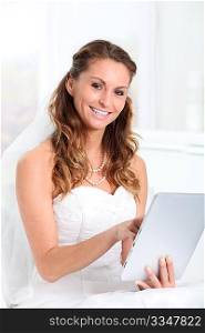 Beautiful bride websurfing on electronic tablet