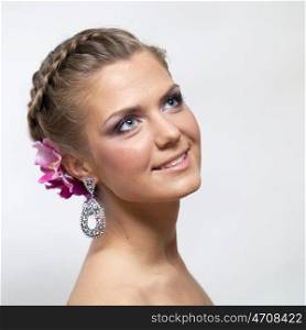 Beautiful bride with fashion wedding hairstyle - on gray background