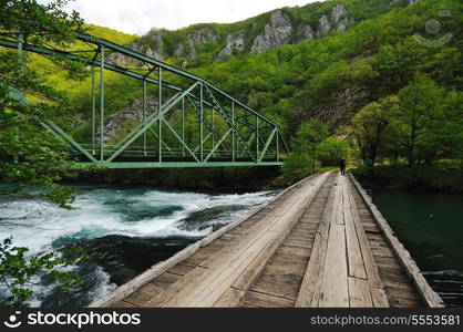 beautiful bridge in nature over wild river