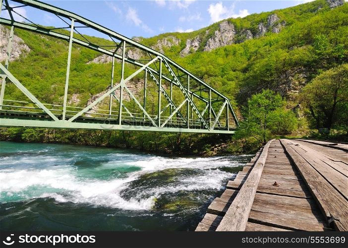 beautiful bridge in nature over wild river