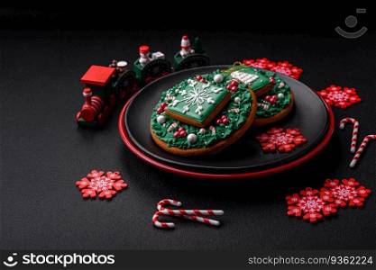 Beautiful bright colorful homemade gingerbread cookies on a ceramic plate on a dark concrete background