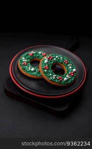 Beautiful bright colorful homemade gingerbread cookies on a ceramic plate on a dark concrete background