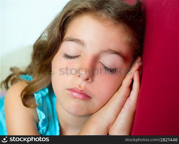 beautiful brunete kid girl sleeping hands together on red sofa