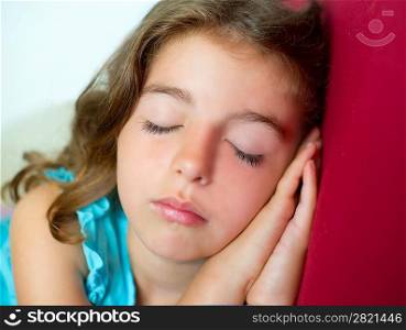 beautiful brunete kid girl sleeping hands together on red sofa