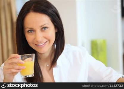 beautiful brunette drinking orange juice