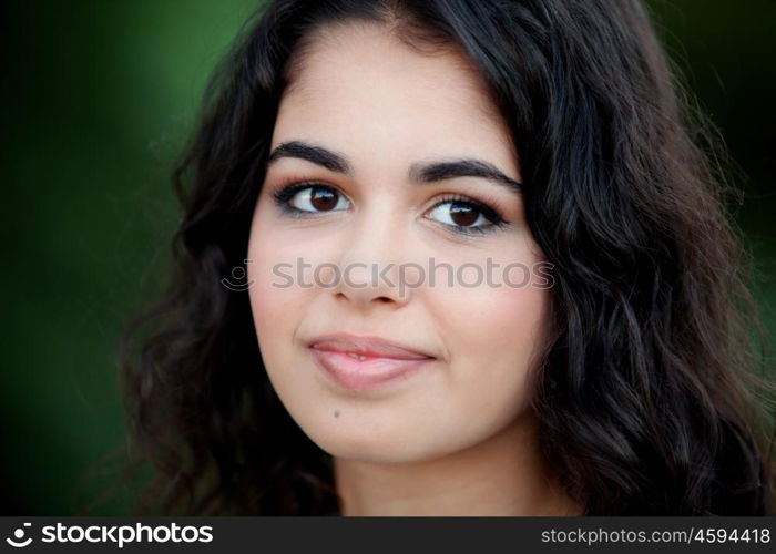 Beautiful brunette girl relaxing in the park wiht many plants of background