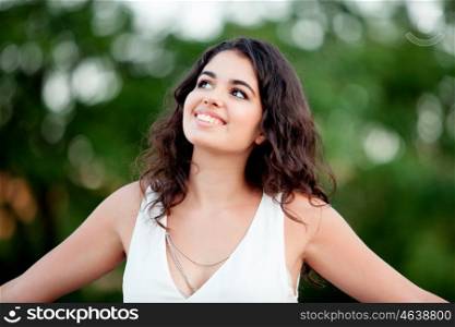 Beautiful brunette girl relaxing in the park wiht many plants of background