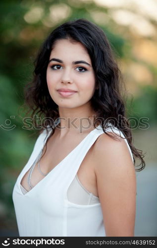 Beautiful brunette girl relaxing in the park wiht many plants of background