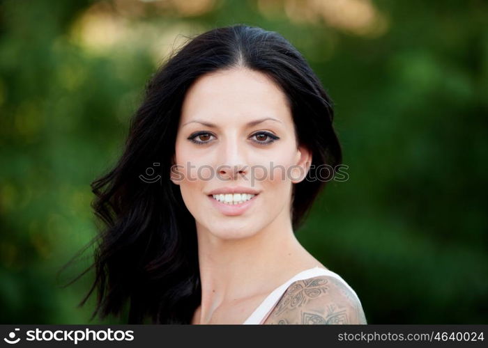 Beautiful brunette girl relaxing in the park wiht many plants of background