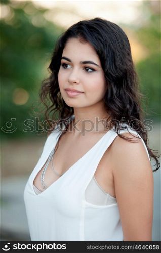 Beautiful brunette girl relaxing in the park wiht many plants of background