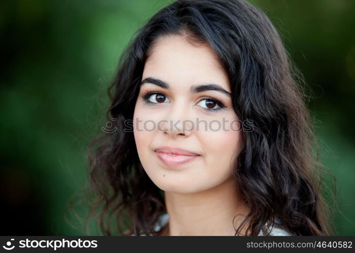 Beautiful brunette girl relaxing in the park wiht many plants of background