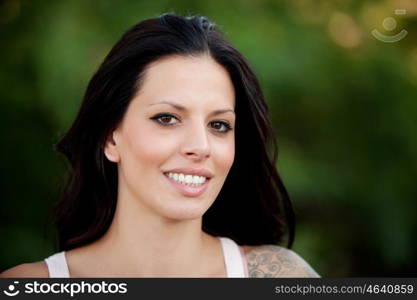 Beautiful brunette girl relaxing in the park wiht many plants of background