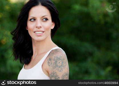 Beautiful brunette girl relaxing in the park wiht many plants of background