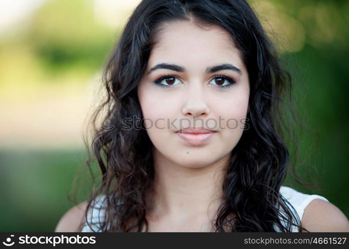 Beautiful brunette girl relaxing in the park wiht many plants of background