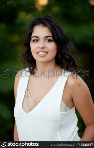 Beautiful brunette girl relaxing in the park wiht many plants of background