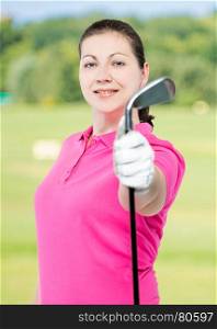 beautiful brunette golfer with a club in his hand on a background of golf courses