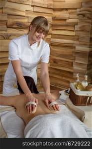 Beautiful brunette having wooden brush massage at luxury spa