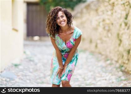 Beautiful brunette middle-aged woman in her 40s wearing spring colorful dress outdoors.. Beautiful brunette middle-aged woman wearing spring colorful dress outdoors
