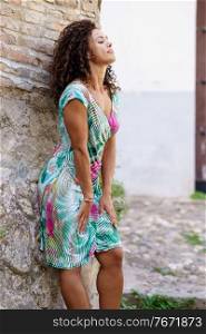 Beautiful brunette middle-aged woman in her 40s wearing spring colorful dress outdoors.. Beautiful brunette middle-aged woman wearing spring colorful dress outdoors