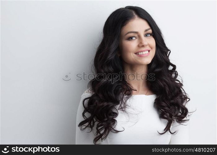 Beautiful brunette model with long curly black hair, studio shot