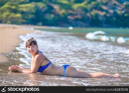 beautiful brunette on a sandy beach in the water