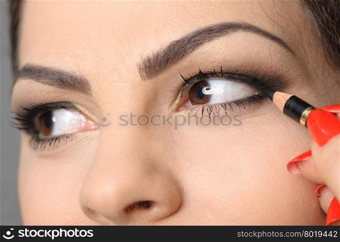 Beautiful brunette portrait, applying perfect makeup to eyes