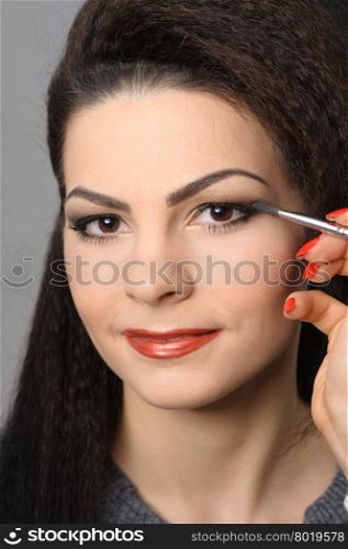 Beautiful brunette portrait, applying perfect makeup to eyes