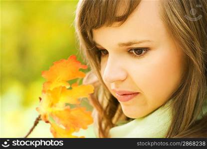 Beautiful brunette with autumn leaves close-up portrait