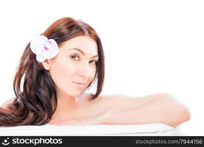 Beautiful brunette with flower in her hair waiting for spa care