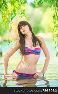beautiful brunette with long hair posing in lake