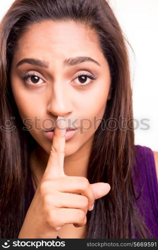 Beautiful brunette woman doing shut up sign