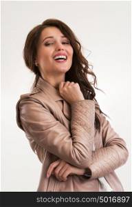 Beautiful brunette woman laughing and looking at camera. Half length portrait