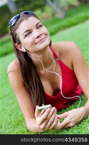 Beautiful Brunette Woman laying Down Listening to MP3 Player