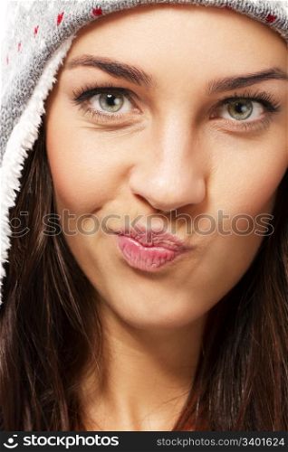 beautiful brunette woman making puss face. beautiful brunette woman wearing winter cap making puss face