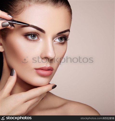 Beautiful Brunette Woman Paints the Eyebrows. Beautiful Woman Face. Makeup Detail. Beauty Girl with Perfect Skin