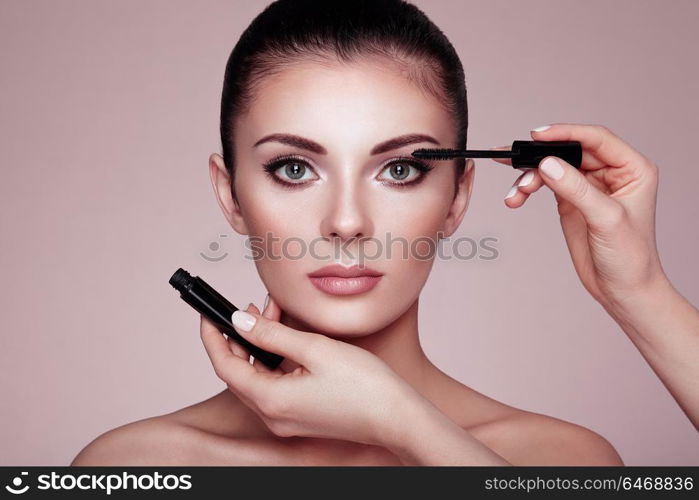 Beautiful Brunette Woman Paints the Eyelashes. Beautiful Woman Face. Makeup Detail. Beauty Girl with Perfect Skin. Make Up in process. Makeup Artis