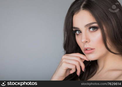 Beautiful brunette woman portrait, healthy hair, clear fresh skin, girl on gray background with copy space for text, skincare, spa, beauty model. Beautiful brunette woman portrait