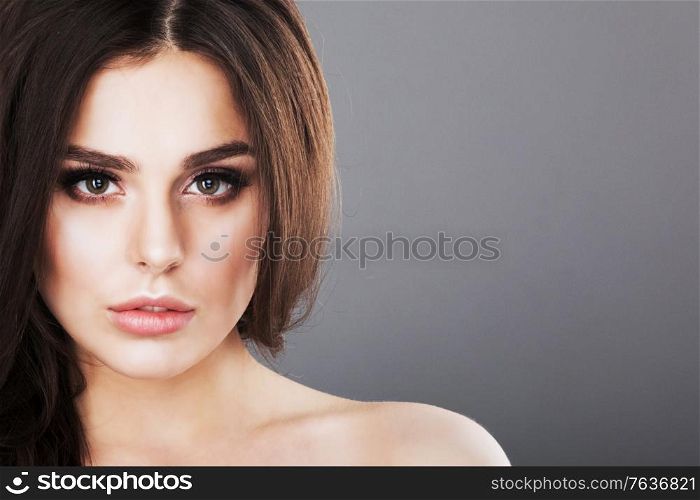 Beautiful brunette woman portrait, healthy hair, clear fresh skin, girl on gray background with copy space for text, skincare., spa, beauty model. Beautiful brunette woman portrait